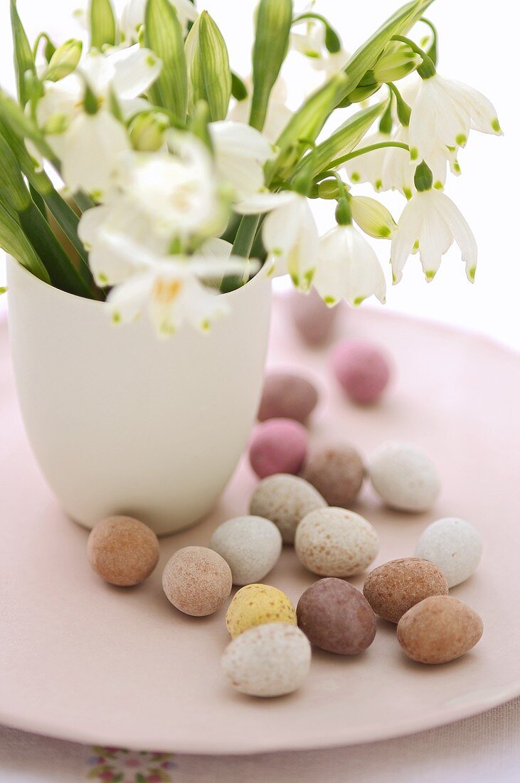 Sweet Easter eggs on a plate with bunch of spring snowflakes