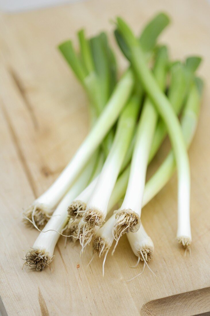 Spring onions on a wooden board