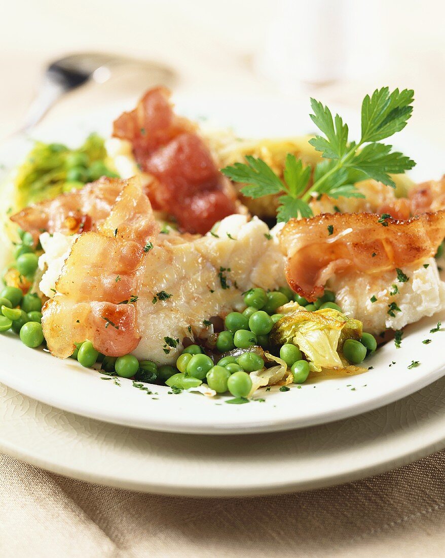 Fish fillet on steamed vegetables with crispy bacon