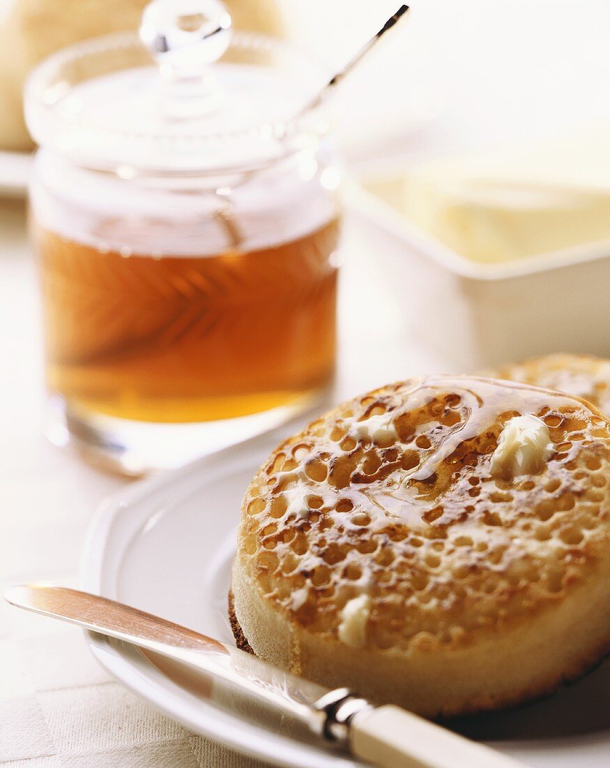 Crumpet with honey (yeast cake cooked on griddle, England)