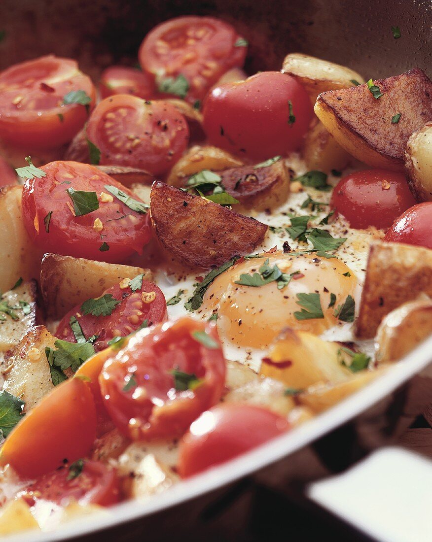 Pan-cooked tomatoes and potatoes with fried egg