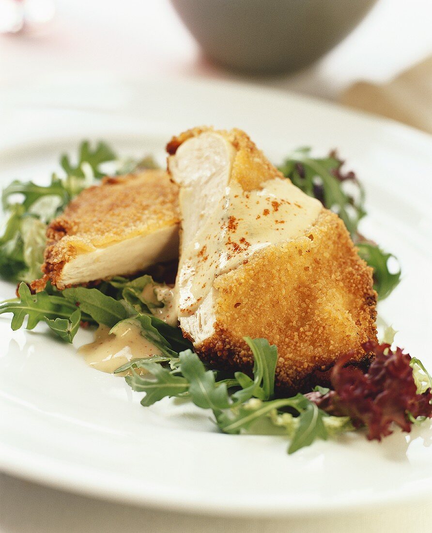 Breaded chicken escalope on salad leaves