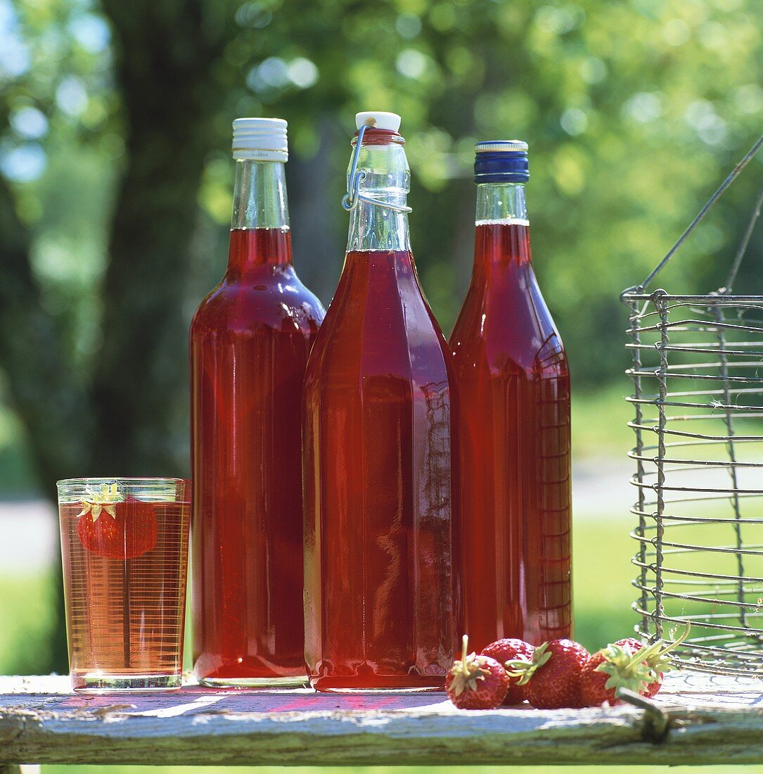 Still life with three bottles of strawberry syrup