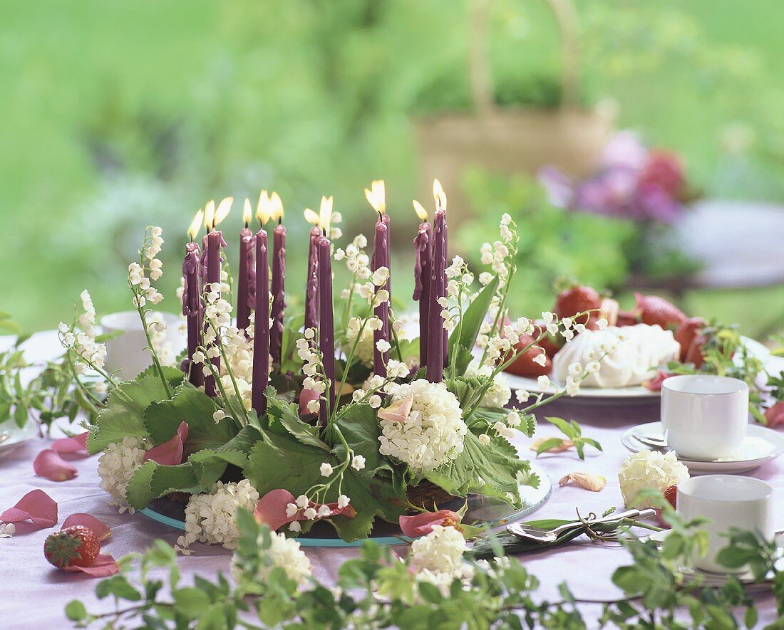 Flower wreath with candles on table laid for coffee