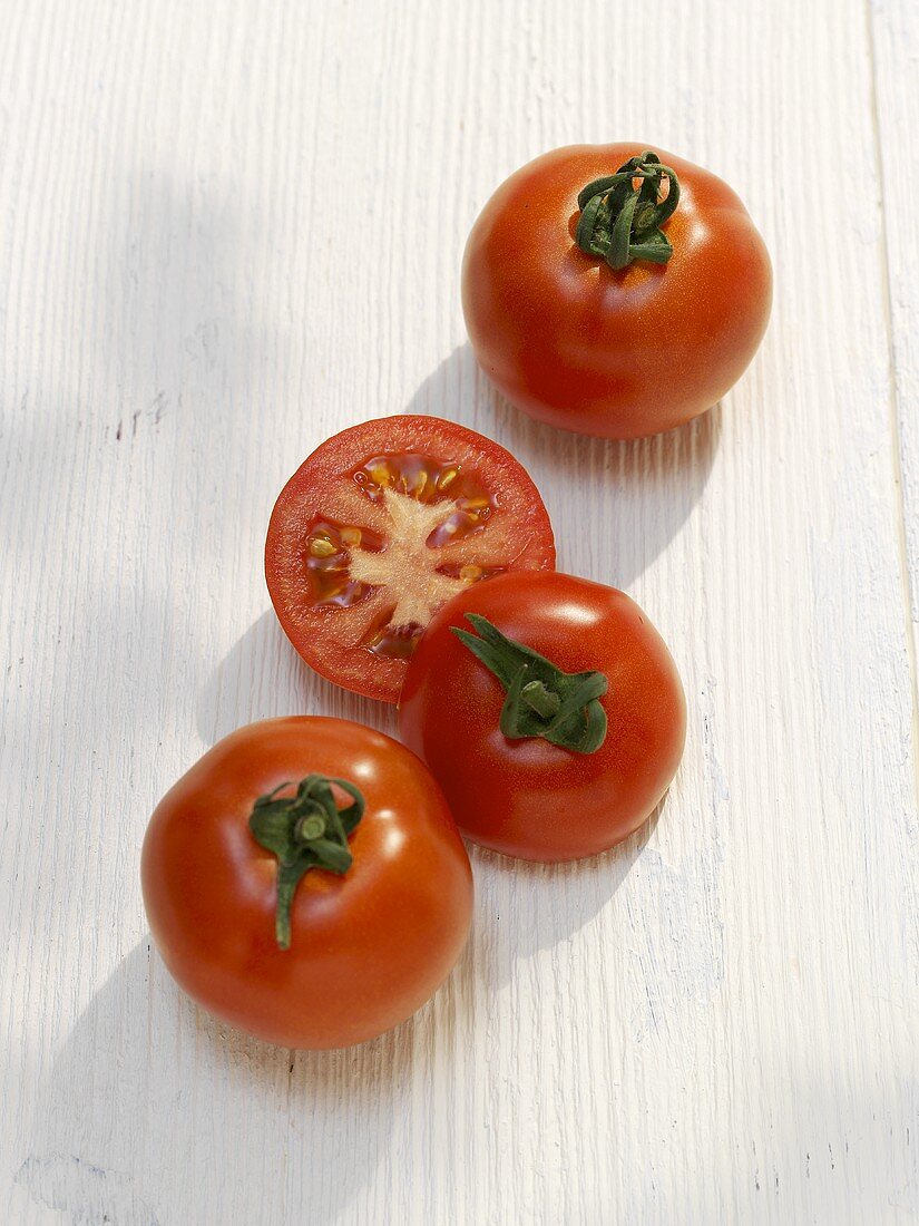 Zwei ganze und eine halbierte Tomate