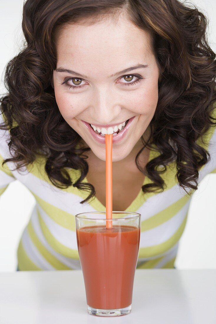 Young woman drinking a glass of tomato juice