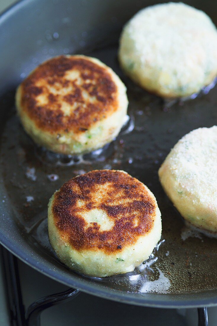 Frying fish cakes in a frying pan