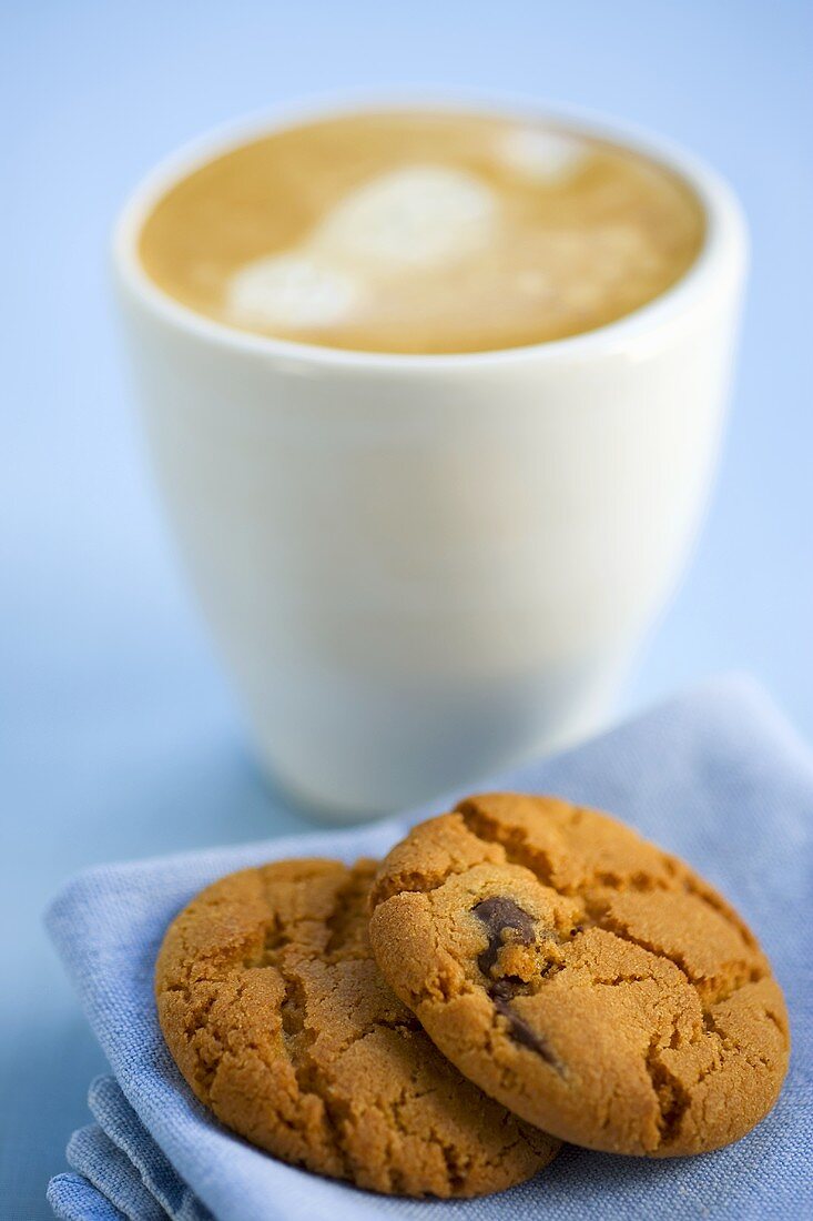 Chocolate chip biscuits and coffee with milk froth