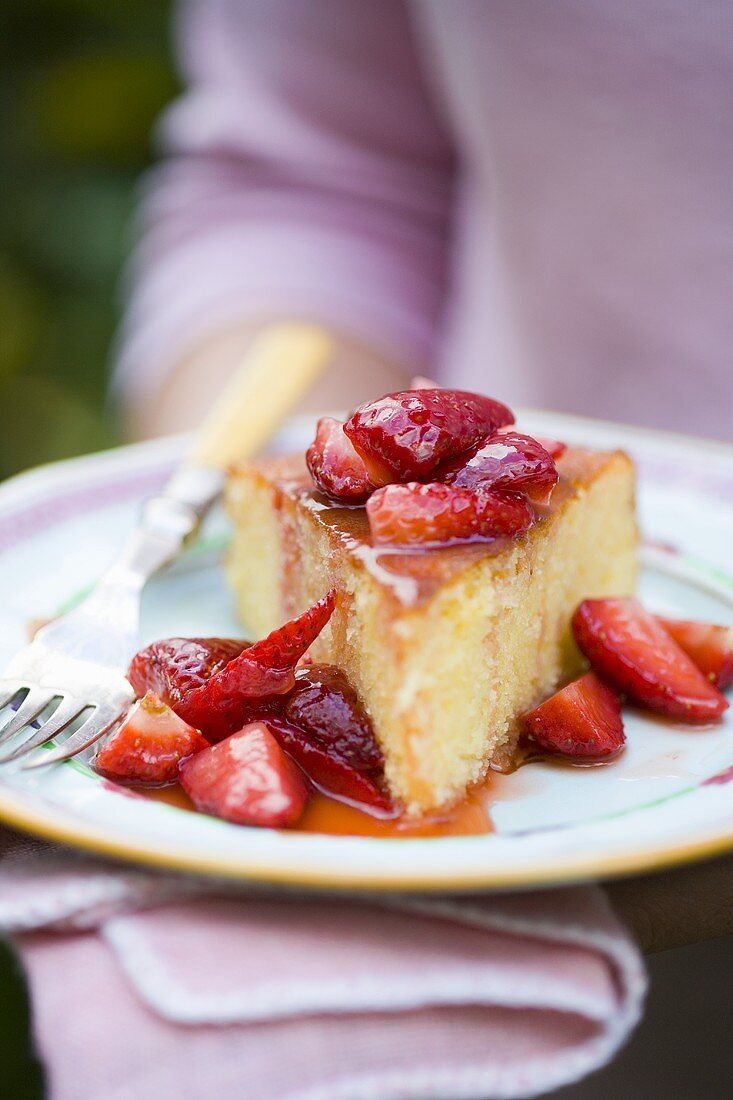 Ein Stück Orangenkuchen mit frischen Erdbeeren