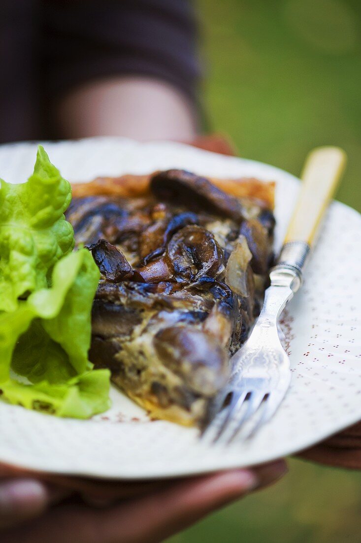 A piece of mushroom tart with lettuce