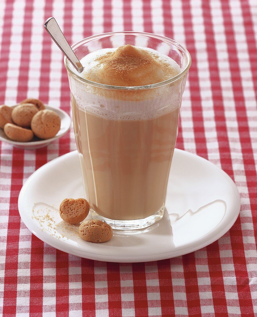 A glass of milky coffee with amaretti
