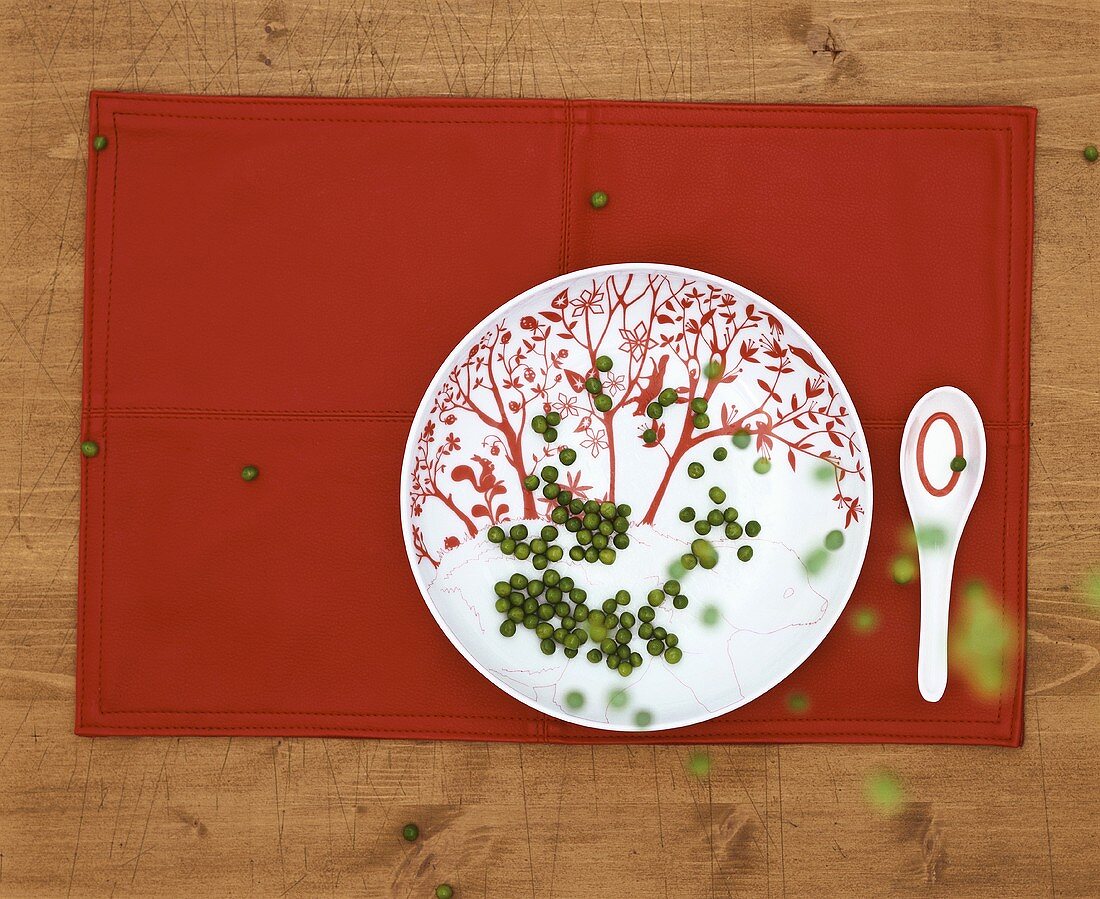 Peas falling onto a plate