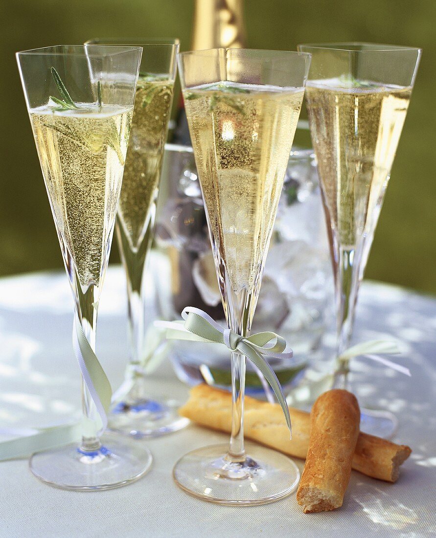 Champagner mit Rosmarin in viereckigen Gläsern