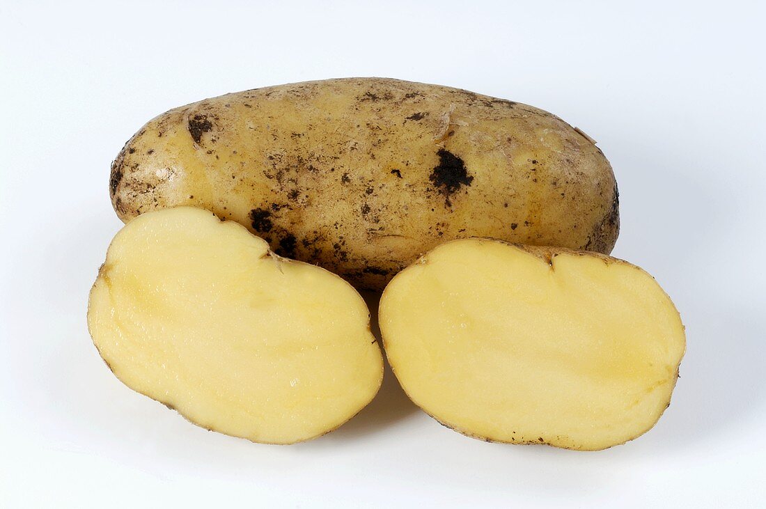 Zwei Kartoffeln der Sorte 'Siglinde' ganz und halbiert