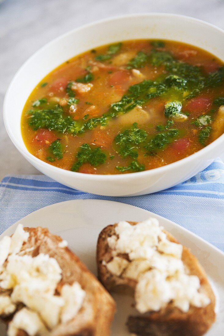 Chicken soup with parsley and bread with goat's cheese