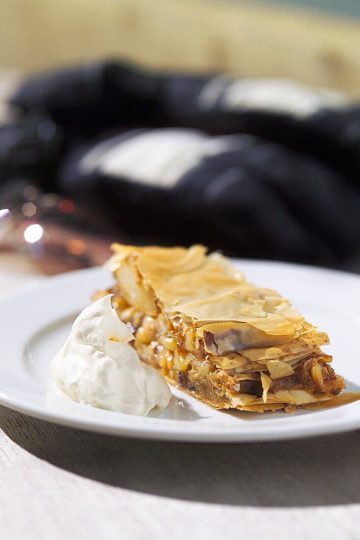 A piece of apple strudel with whipped cream