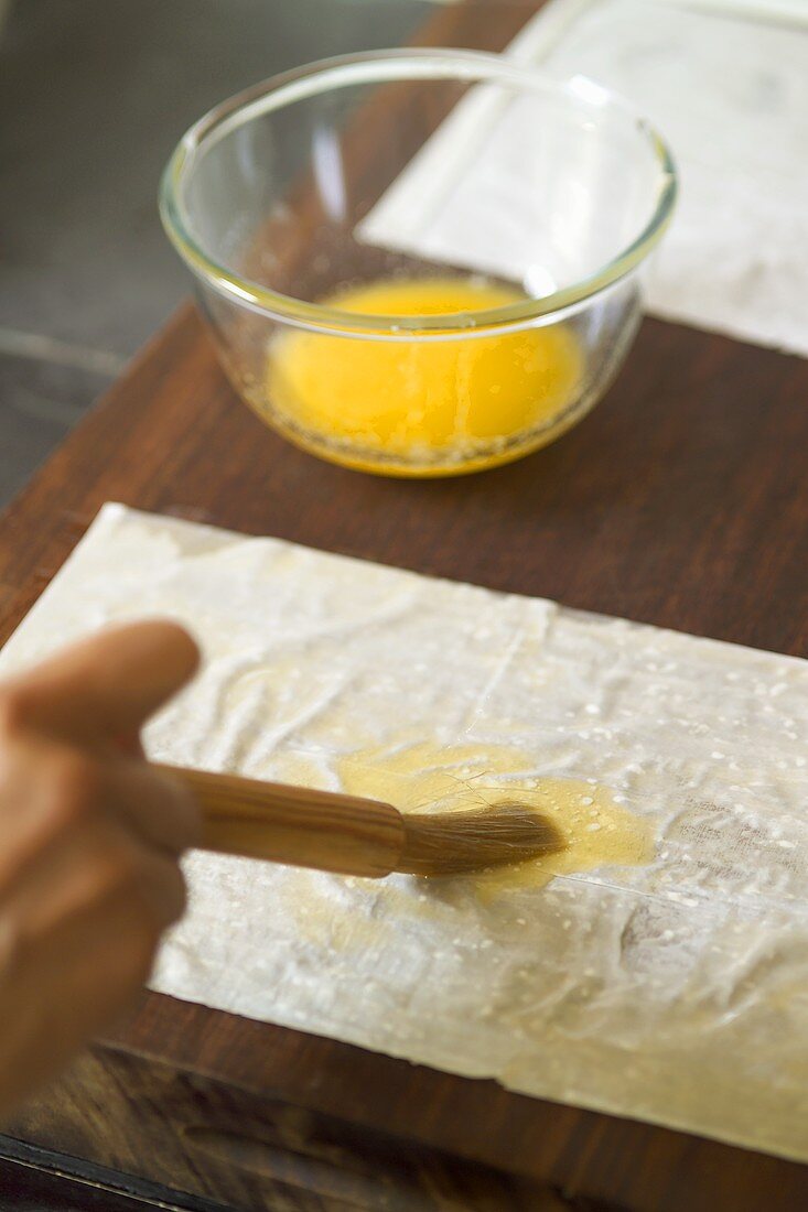 Teigplatte mit zerlassener Butter bestreichen