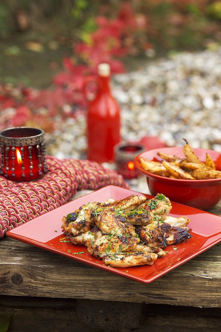 Sweet and sour chicken wings and fried potatoes