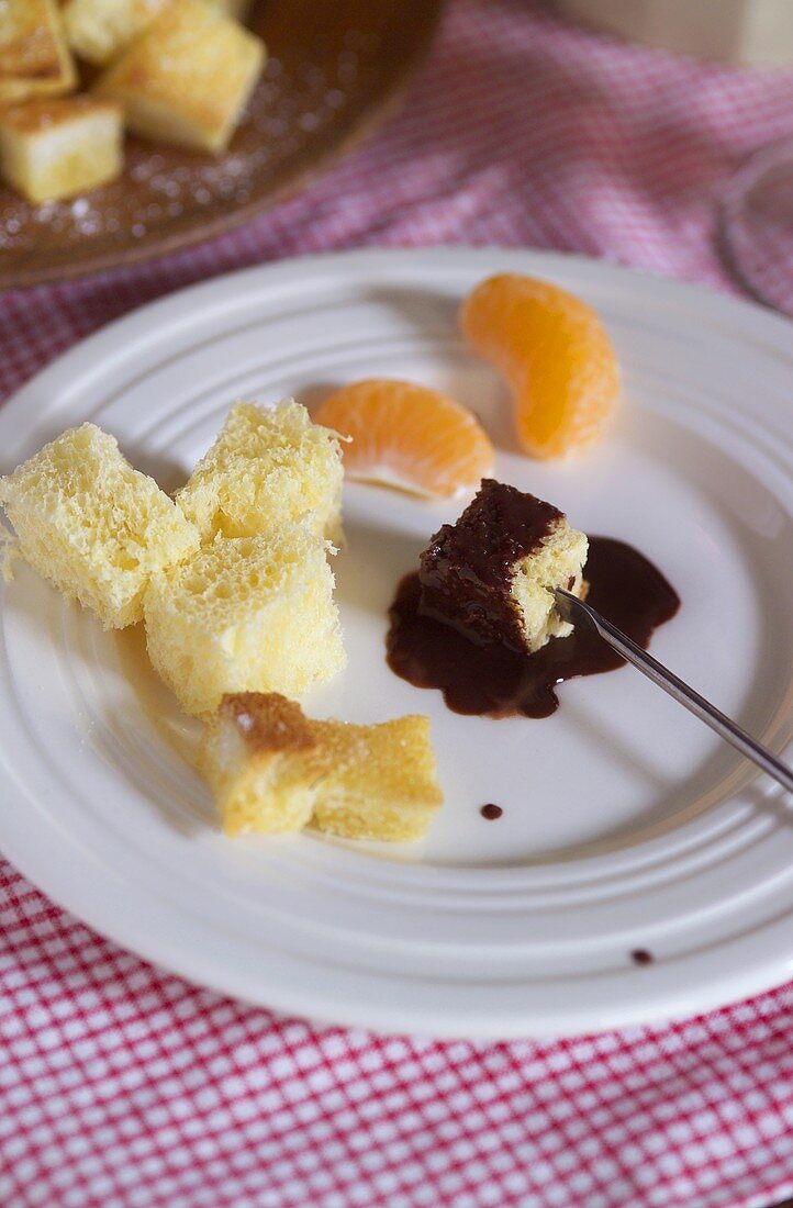 Chocolate fondue with white bread and mandarin oranges