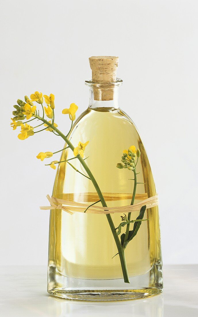 A bottle of rape seed oil with rape flower