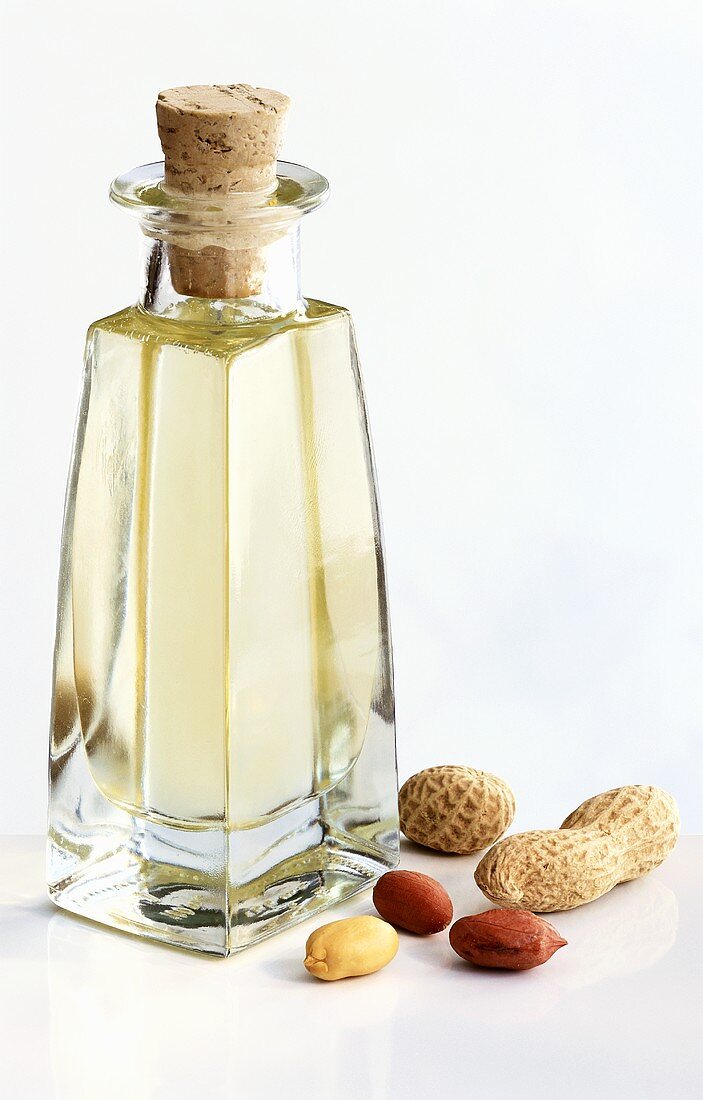 Eine Flasche Erdnussöl und Erdnüsse