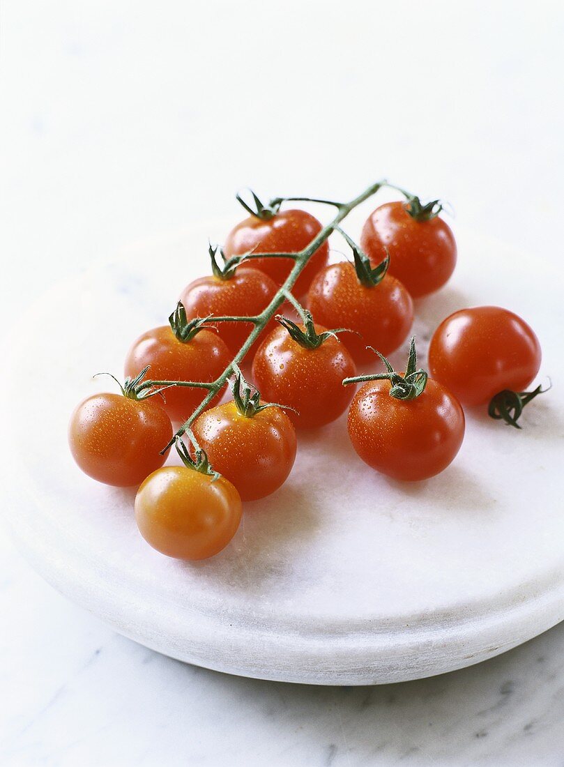 Several cherry tomatoes on a stone slab