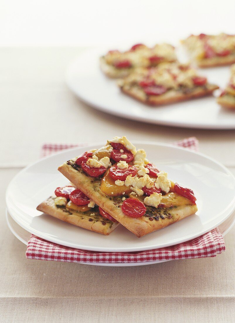 Pizza slices with cherry tomatoes and pesto