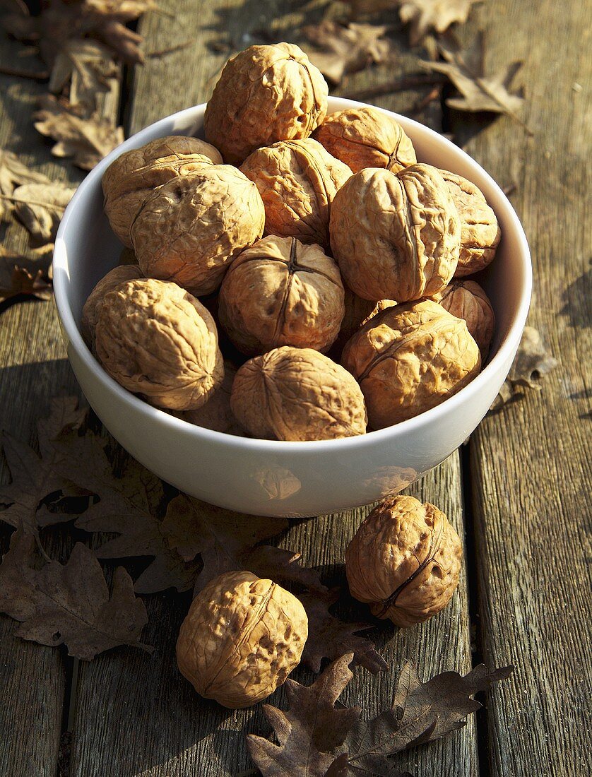 Walnuts in a bowl on wooden background