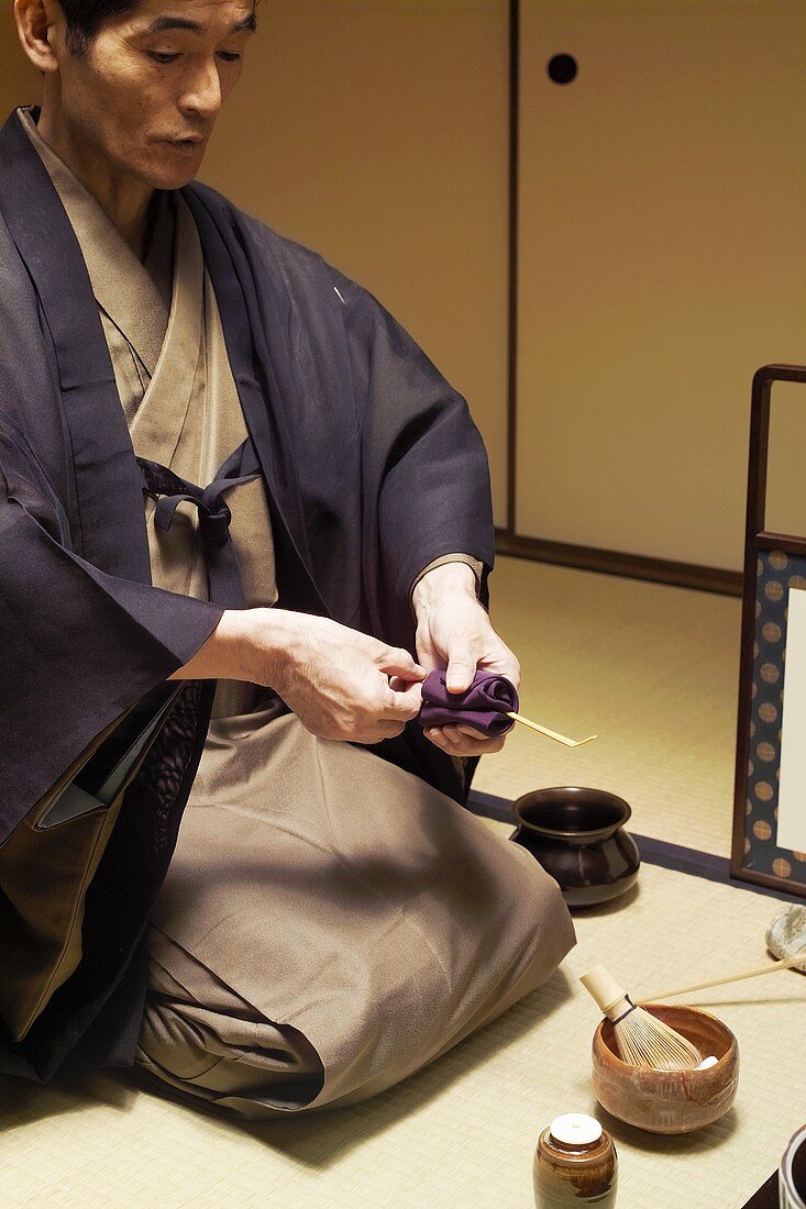 Tea master at tea ceremony, cleaning spoon