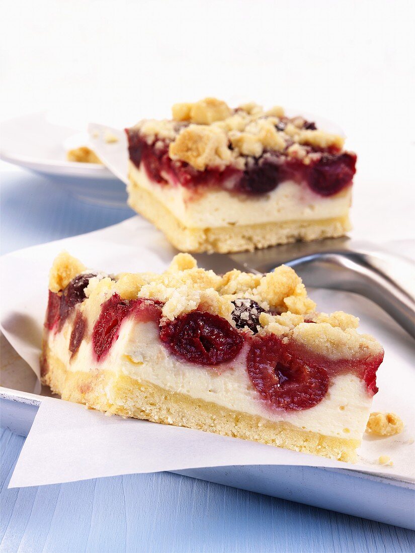 Two pieces of cherry cheesecake with crumble topping