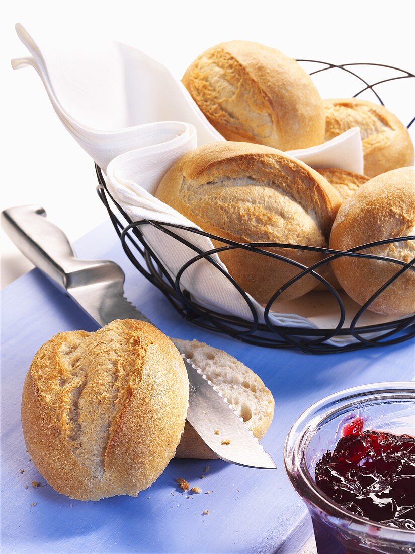 Bread rolls in bread basket and jam