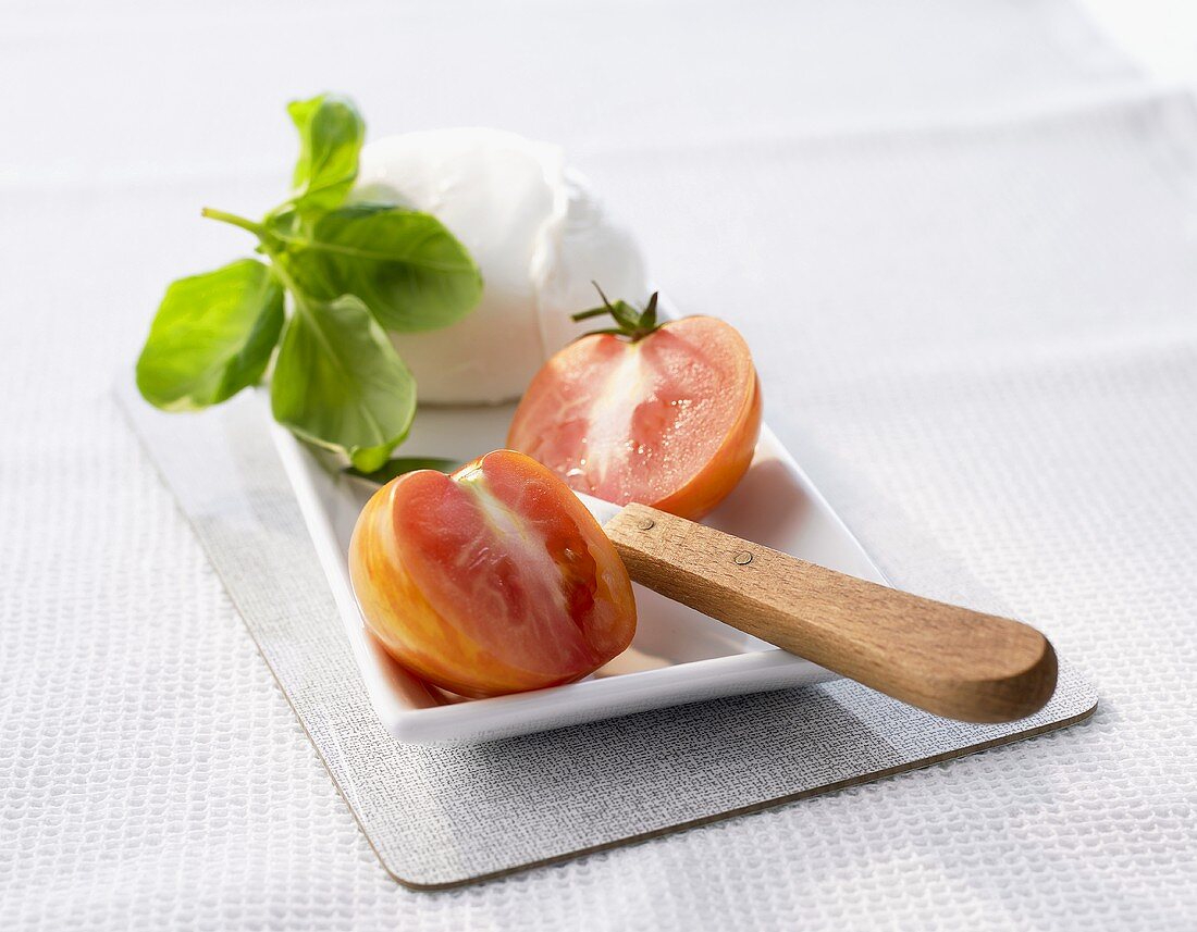 Tiger tomatoes, mozzarella and basil on a platter