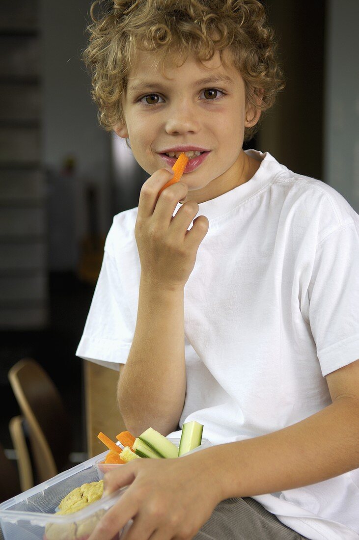 Junge isst Gemüsesticks