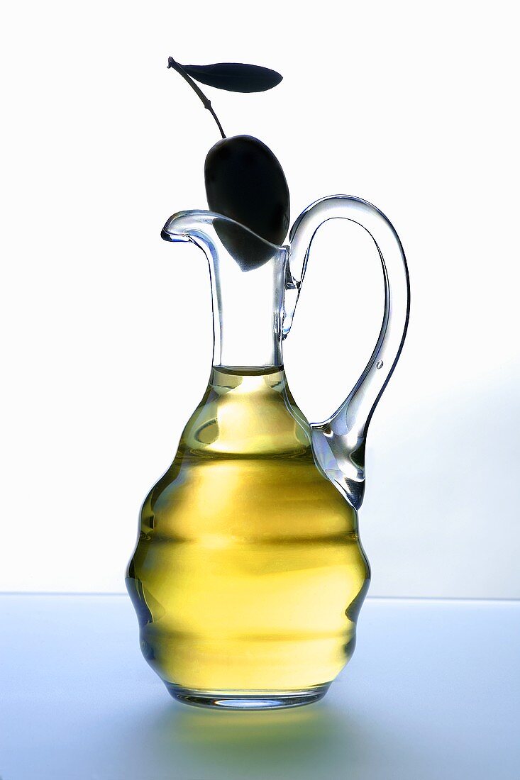 Carafe of olive oil with olive