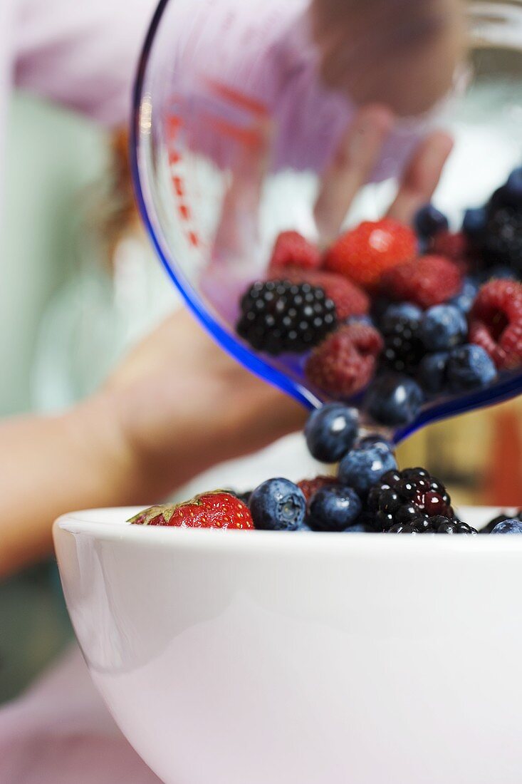 Tipping fresh berries into a bowl
