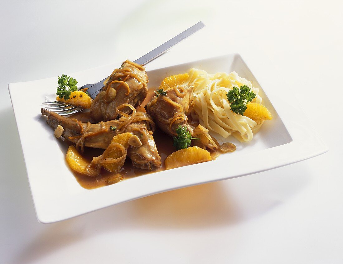 Rabbit with orange sauce and ribbon pasta