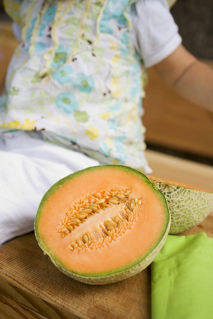 A halved cantaloupe melon on a bench