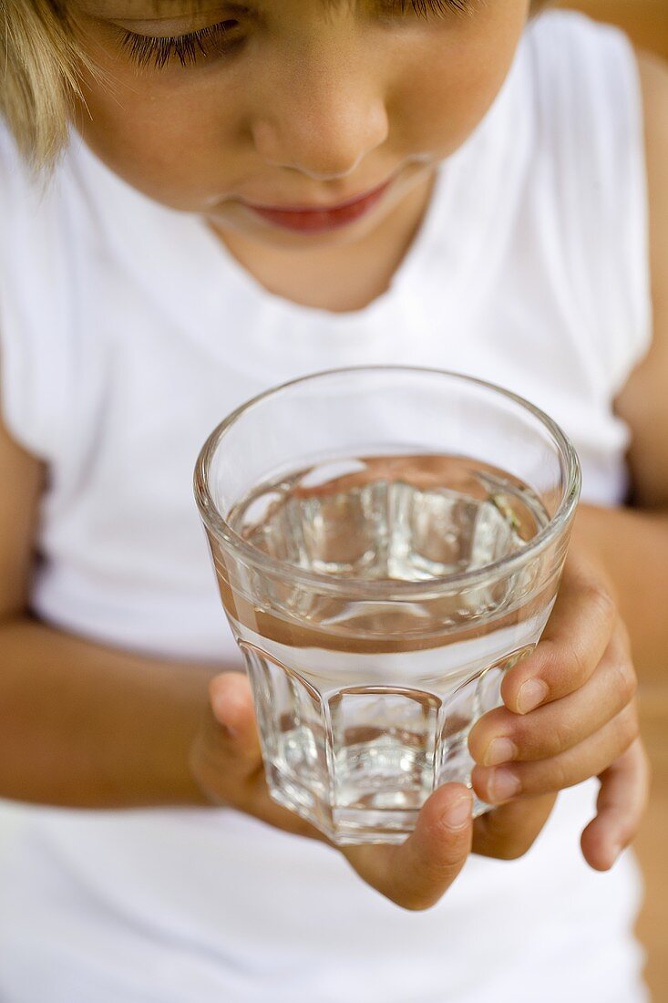 Kind hält ein Glas Wasser
