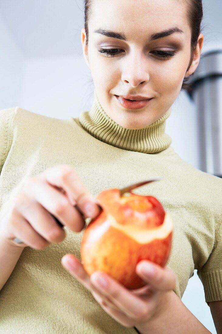 Frau schält einen Apfel