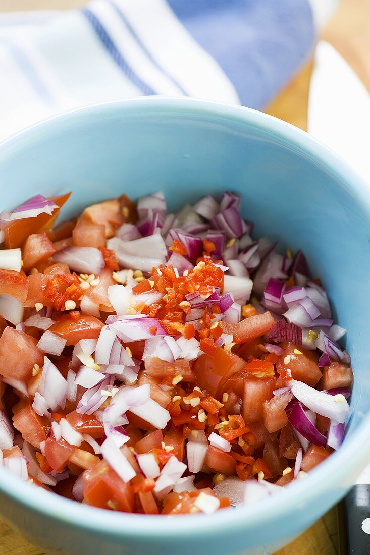 Ingredients for tomato salsa in a small bowl