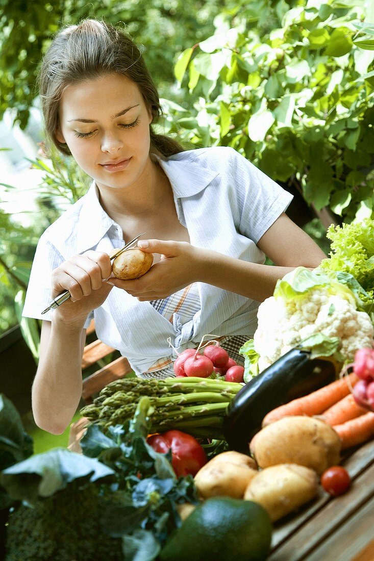 Young woman peeling potatoes