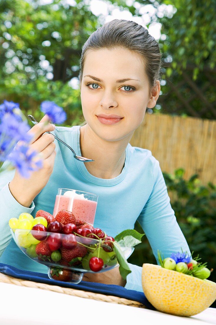 Young woman with fruity cream dessert