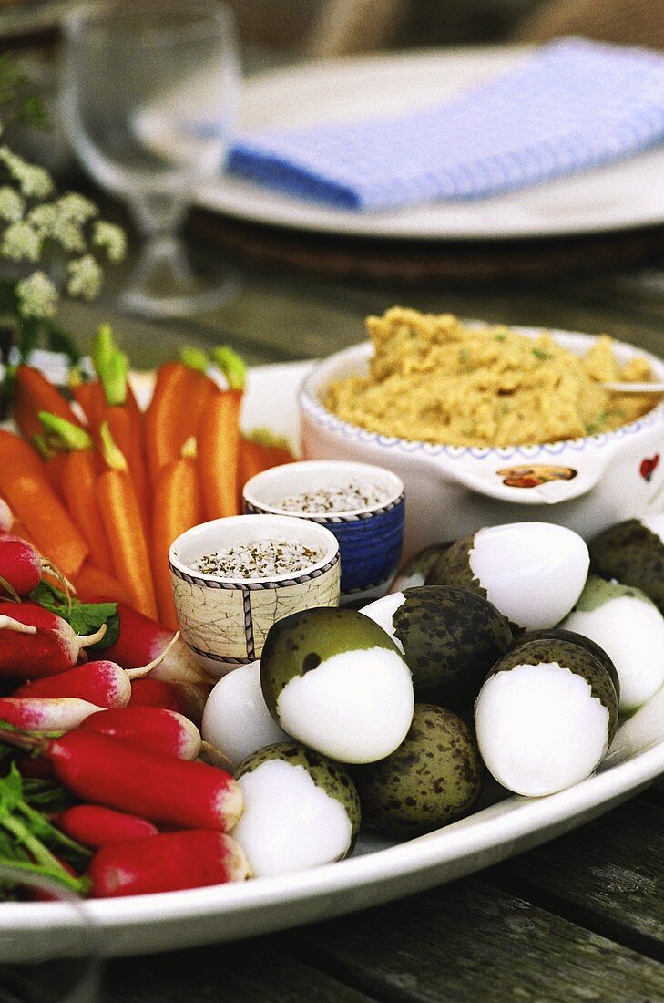 Raw vegetable platter with boiled quails' eggs and dip