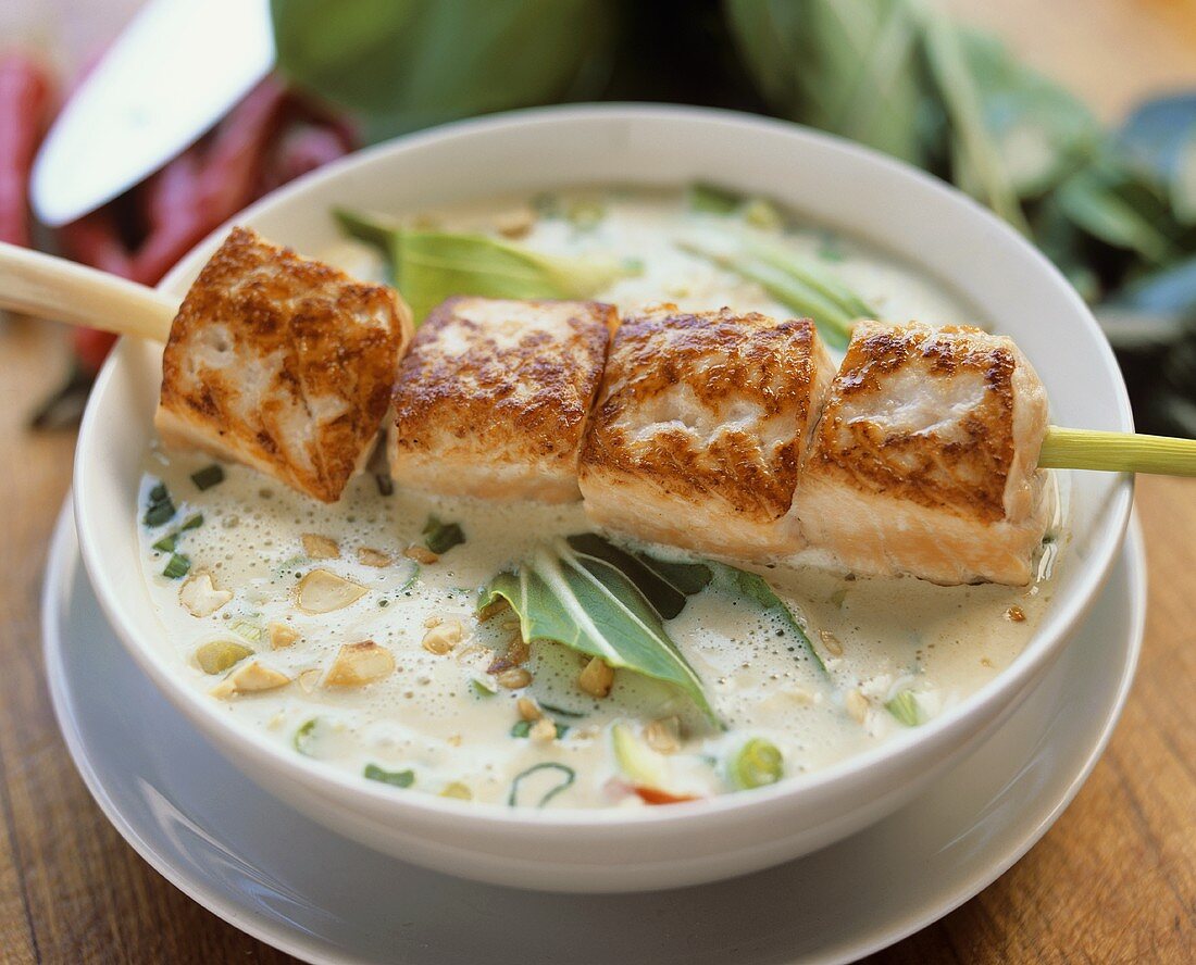 Thai soup with fried skewered salmon