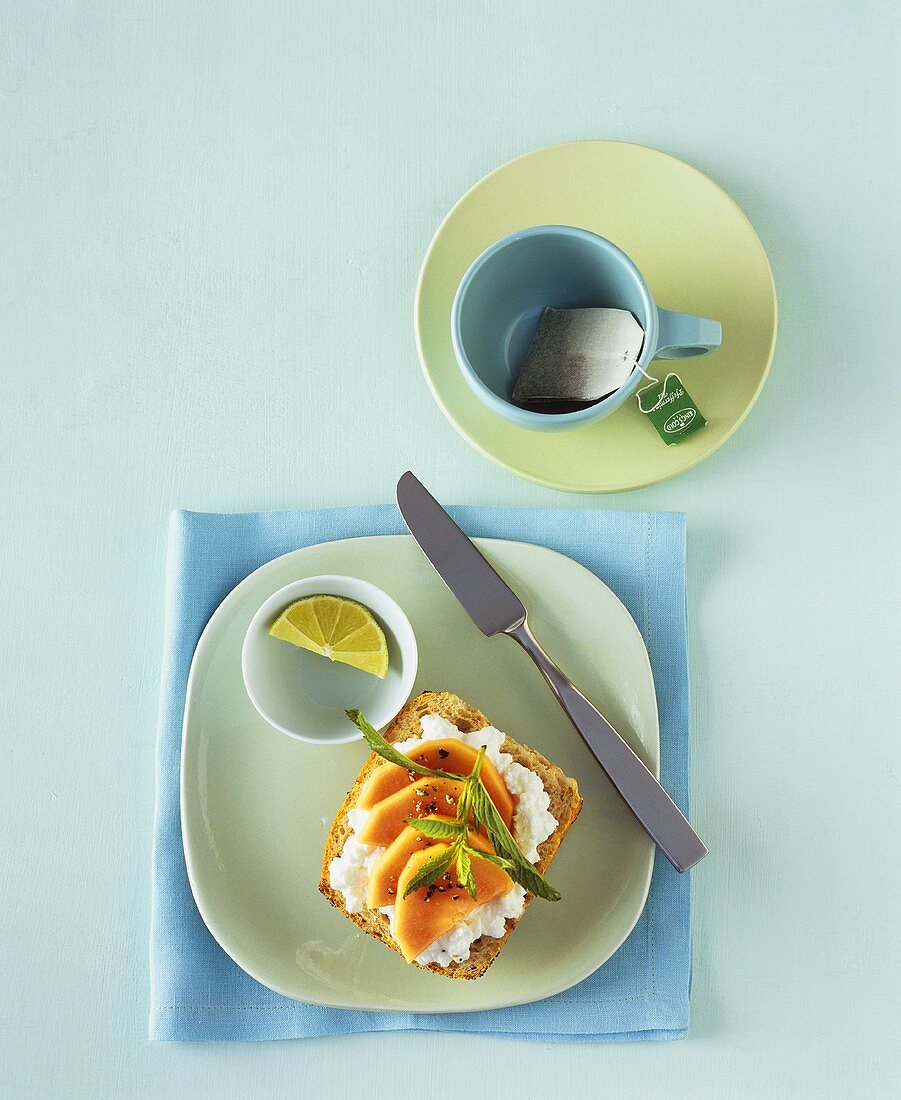 Soft cheese and papaya on wholemeal roll, teacup