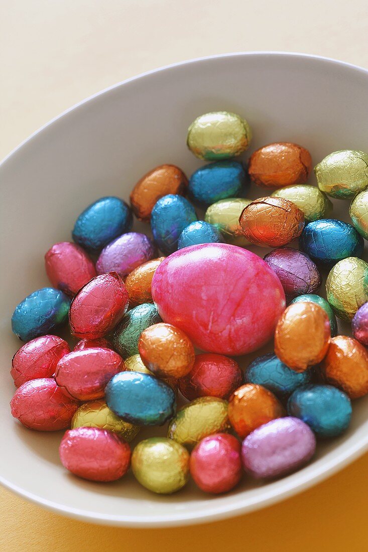 Chocolate eggs and a coloured egg in a dish