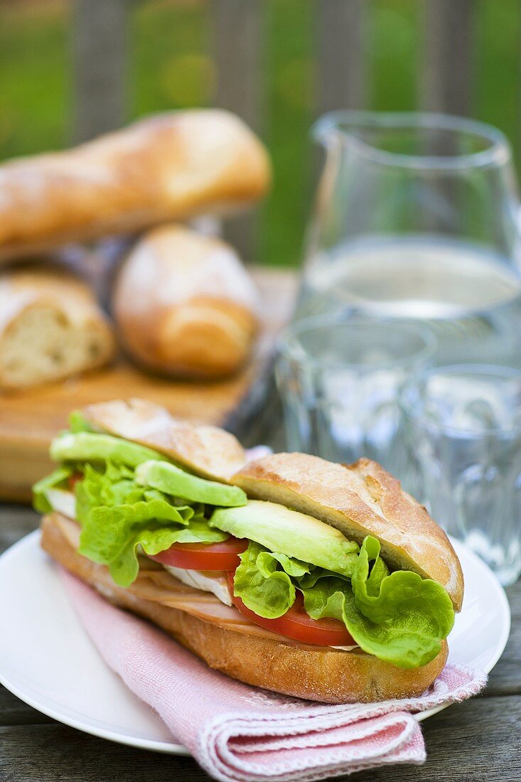 Sandwich mit Hähnchenbrust auf einem Gartentisch