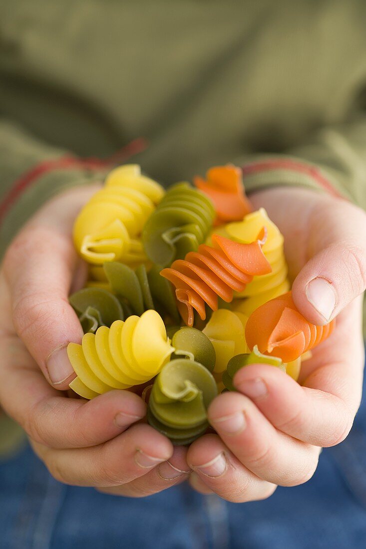 Coloured pasta in child's hands