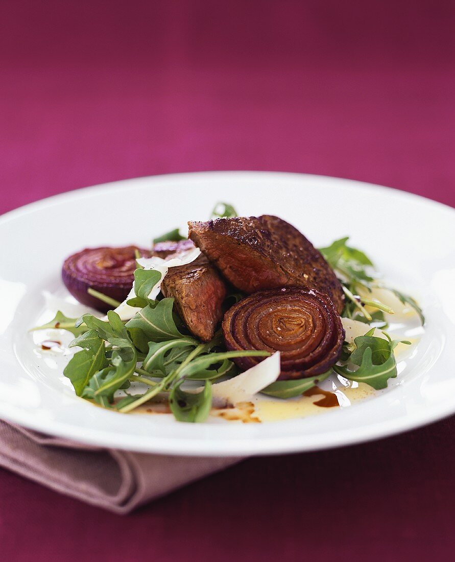 Fried beef fillet with red onions, rocket and Parmesan