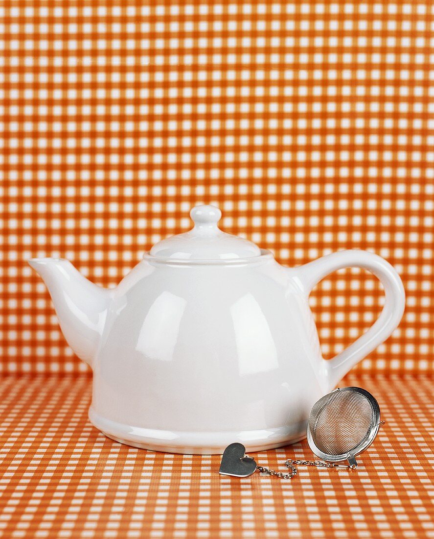 White teapot and tea strainer